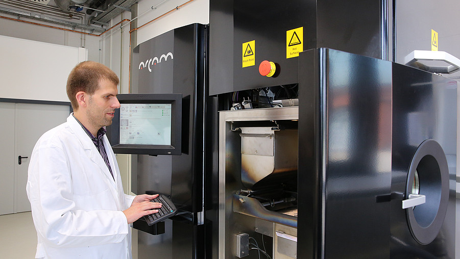 Prof. Dr.-Ing. Thomas Niendorf at a 3D printer for metal.